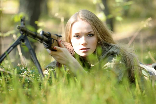 Молодая блондинка с винтовкой в руках — стоковое фото