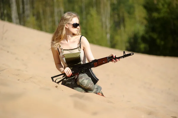 Jovem loira com um rifle em suas mãos — Fotografia de Stock