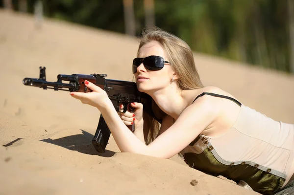 Jovem loira com um rifle em suas mãos — Fotografia de Stock