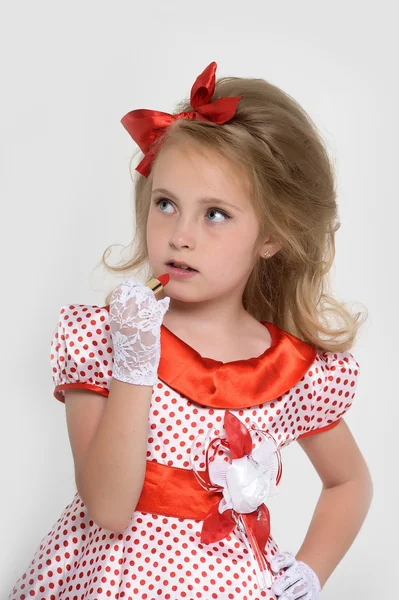 Little girl paints lips with lipstick — Stock Photo, Image