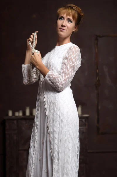 Jonge vrouw in witte jurk in interieur — Stockfoto