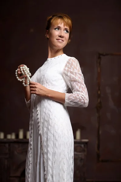 インテリアの白いドレスの若い女性 — ストック写真