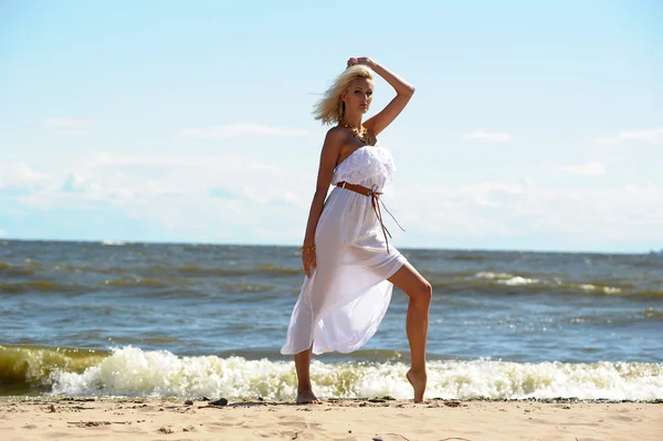 Mädchen im weißen Kleid am Strand — Stockfoto