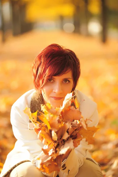 Girl with autumn leaves in the park — Stock Photo, Image