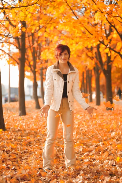 Flicka med höstlöv i parken — Stockfoto