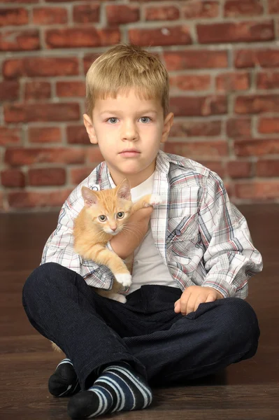 Niño con un gatito pequeño — Foto de Stock