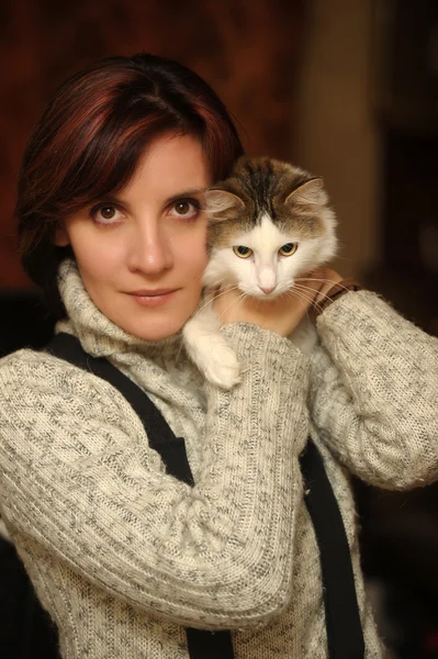 Mujer joven con un gato en sus brazos — Foto de Stock
