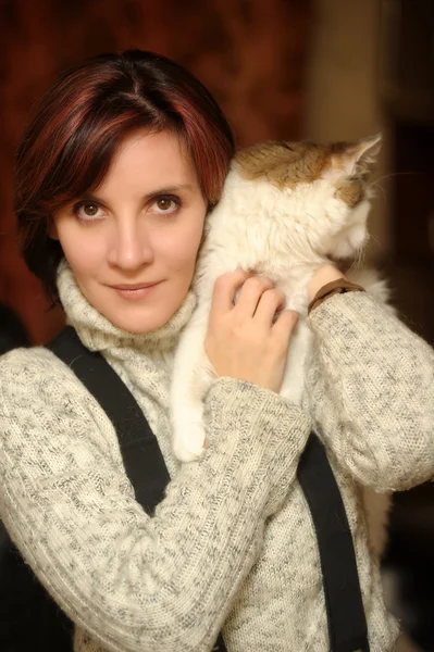 Mujer joven con un gato en sus brazos — Foto de Stock