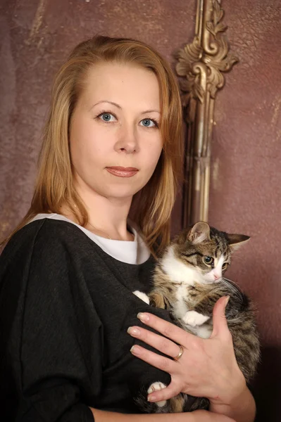 Young woman with a kitten in her arms — Stock Photo, Image