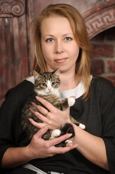 Jovem mulher com um gatinho em seus braços — Fotografia de Stock