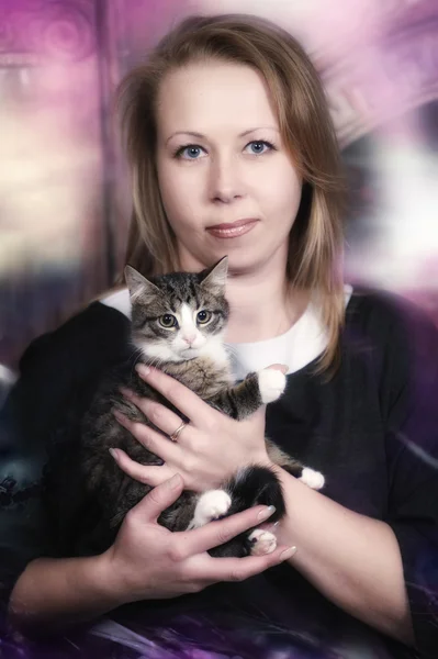 Young woman with a kitten in her arms — Stock Photo, Image