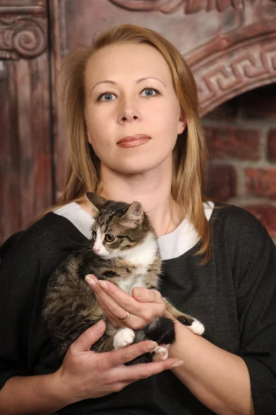 彼女の腕に子猫を持つ若い女性は — ストック写真