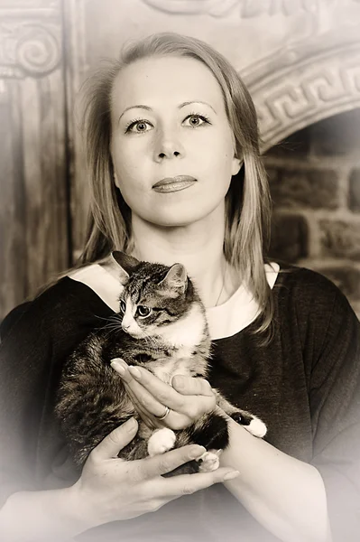 Young woman with a kitten in her arms — Stock Photo, Image