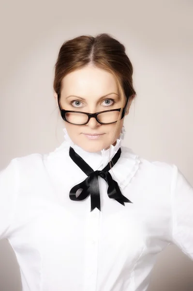 Vrouw in een witte blouse met een boog en glazen — Stockfoto