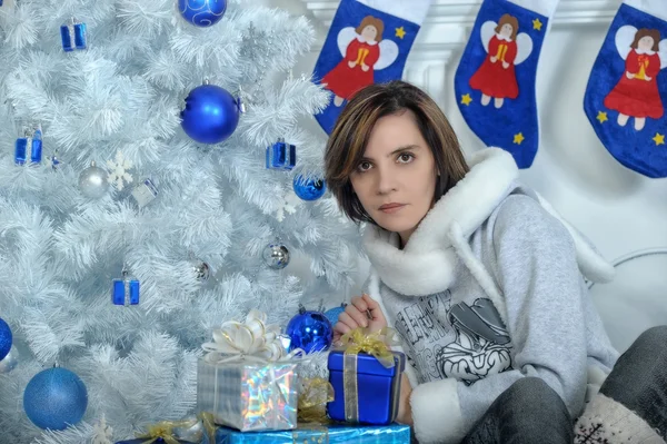 Ung kvinna i en jul inredning i blå toner — Stockfoto