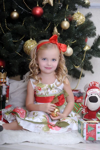 Χαριτωμένο κοριτσάκι μπροστά από ένα χριστουγεννιάτικο δέντρο — Φωτογραφία Αρχείου