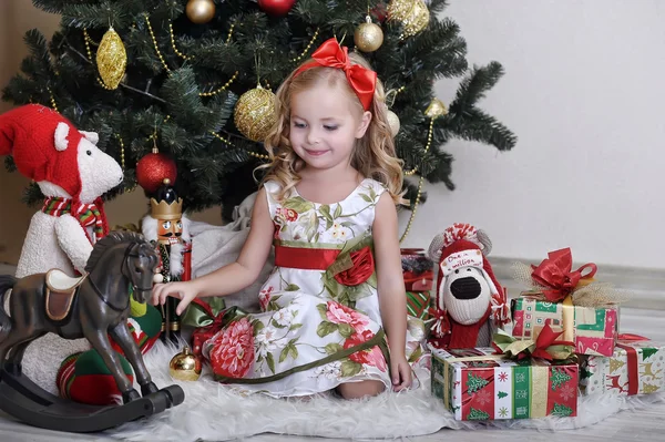 Χαριτωμένο κοριτσάκι μπροστά από ένα χριστουγεννιάτικο δέντρο — Φωτογραφία Αρχείου