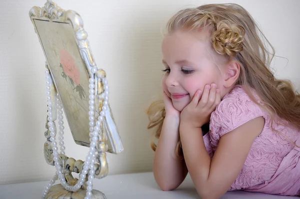 Beautiful little girl looking to retro mirror — Stock Photo, Image