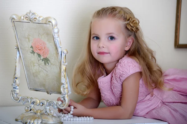 Hermosa niña mirando al espejo retro — Foto de Stock