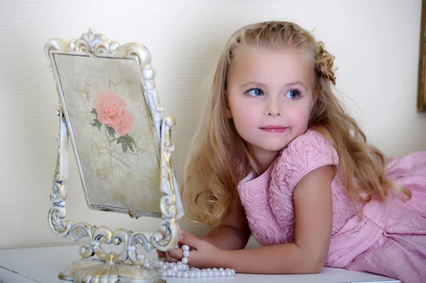 Hermosa niña mirando al espejo retro — Foto de Stock