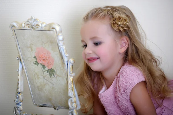 Hermosa niña mirando al espejo retro — Foto de Stock