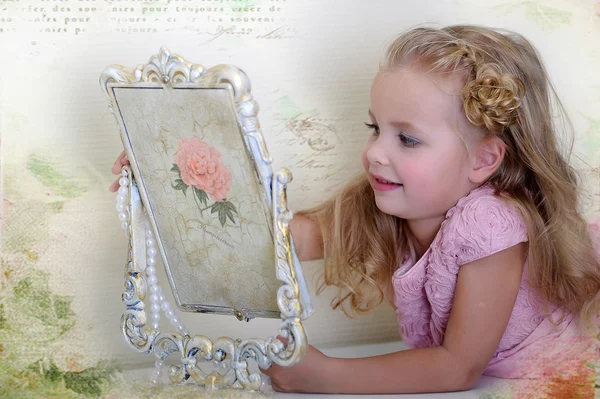 Красива маленька дівчинка дивиться на ретро дзеркало — стокове фото