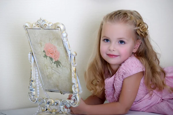 Beautiful little girl looking to retro mirror — Stock Photo, Image