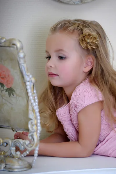 Hermosa niña mirando al espejo retro — Foto de Stock