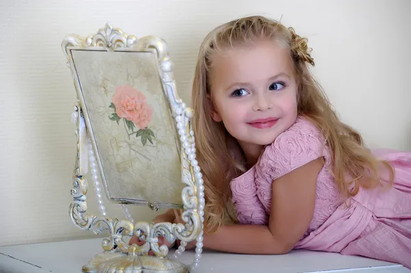 Beautiful little girl looking to retro mirror — Stock Photo, Image