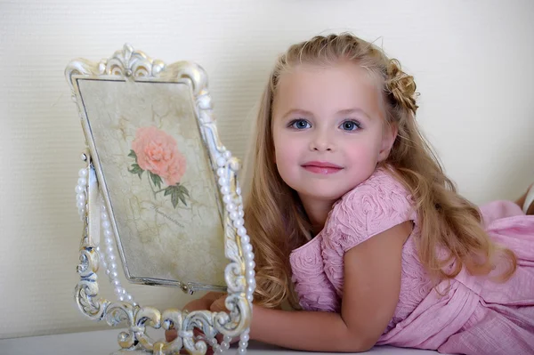 Beautiful little girl looking to retro mirror — Stock Photo, Image