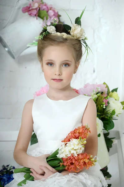 Mooi meisje in witte jurk met een bloem — Stockfoto