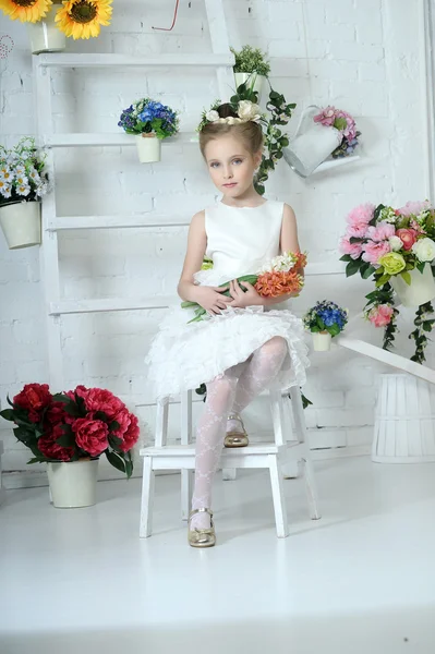 Menina bonita em vestido branco com uma flor — Fotografia de Stock