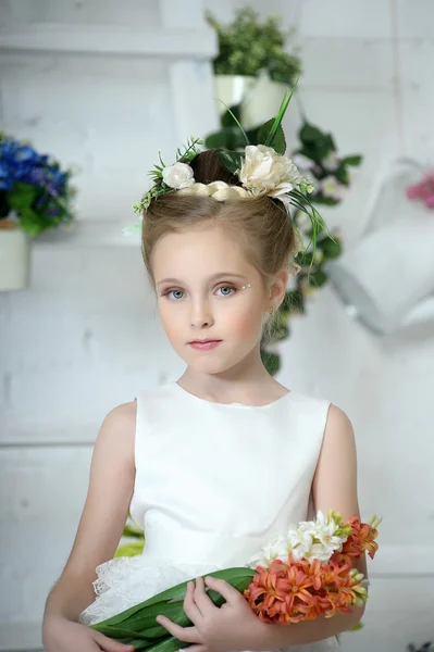 Mooi meisje in witte jurk met een bloem — Stockfoto