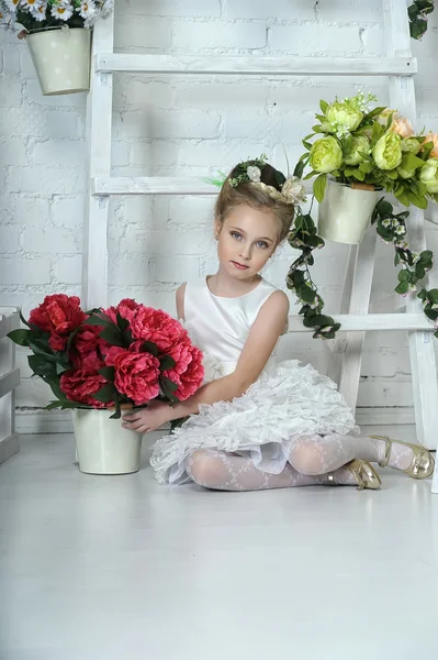 Mooi meisje in witte jurk met een bloem — Stockfoto
