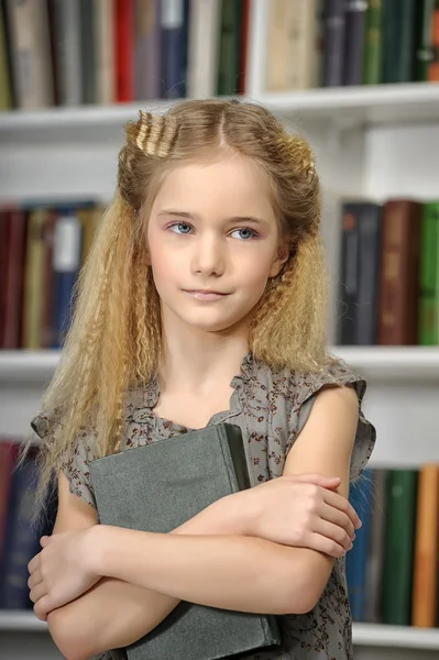 Дівчина з книгами в бібліотеці — стокове фото