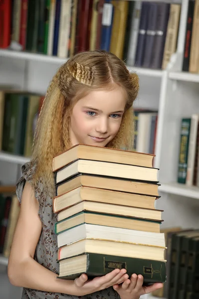 Κορίτσι στη βιβλιοθήκη με μια στοίβα από βιβλία — Φωτογραφία Αρχείου