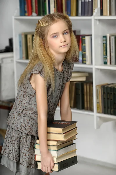 書籍のスタックを持つライブラリの女の子 — ストック写真