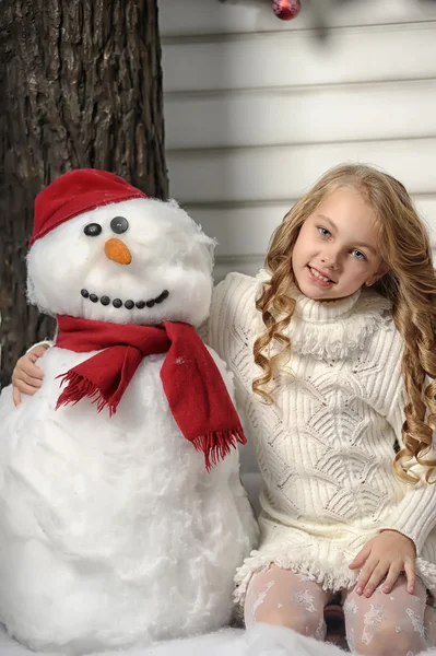 Κορίτσι αγκαλιάζει μια χαρούμενη χιονιά — Φωτογραφία Αρχείου