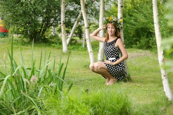 Frau mit einer Blumenkrone neben einer Birke — Stockfoto