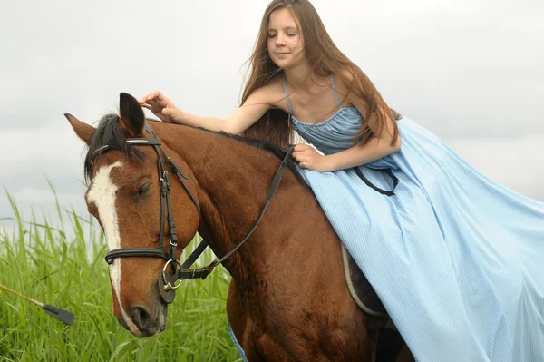 Teen girl in a dress on a horse — Stockfoto