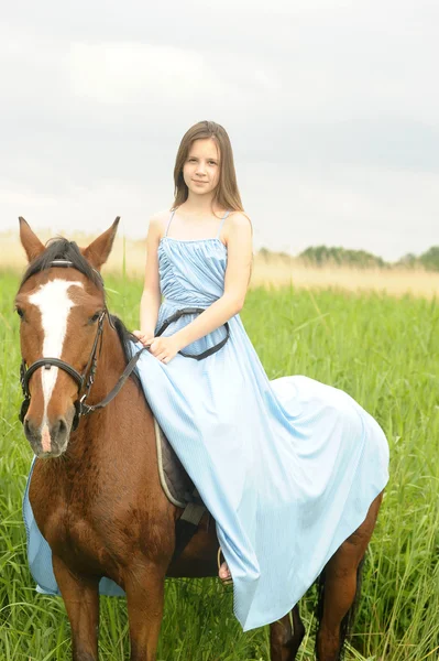 Ragazza adolescente in un vestito su un cavallo — Foto Stock