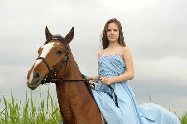 Teen girl in a dress on a horse — Stockfoto