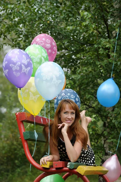 Jeune femme avec des ballons en latex coloré — Photo