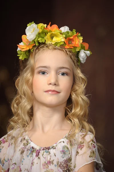 Retrato de una niña con una rama de flores en la cabeza —  Fotos de Stock