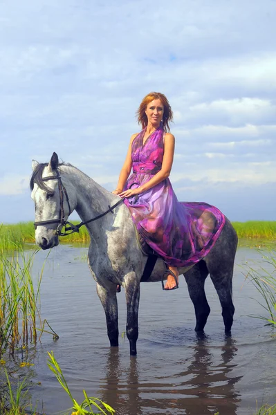 Młoda kobieta w sukni na koniu w wodzie — Zdjęcie stockowe