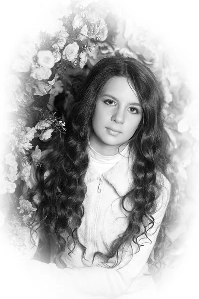 Gyönyörű lány, egy virágos háttér — Stock Fotó