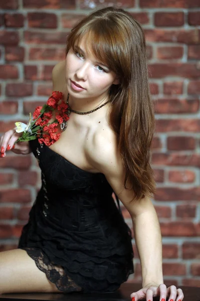 Seductive woman with red flowers — Stock Photo, Image