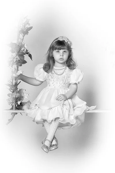 Niña en un columpio decorado con flores — Foto de Stock