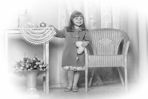 Little girl stands near a table — Stock Photo, Image