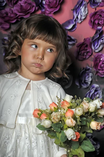 Całkiem mała dziewczynka na tle kwiatów — Zdjęcie stockowe
